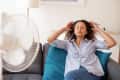 Black woman portrait cooling off at home during summer heat
