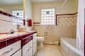 Ivory tones bathroom with old bathroom vanity cabinet and glass block window