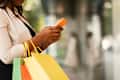 woman with shopping bags texting