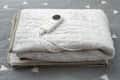 folded electric blanket with controller on the bed at horizontal composition