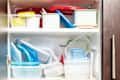kitchen cabinet full of plastic food containers arranged in a haphazard manner