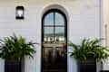 White brick building with arched black Dutch door