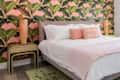 Bedroom with pink and green accent colors and tropical wallpaper theme