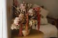 Dry hydrangea, poppy and amaranth in stylish vase close up. Fall decor in modern living room. Thanksgiving and Halloween. Autumn floral arrangement