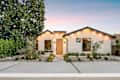 Modern single-story house with a minimalist garden at sunset, featuring clean lines and warm lighting.