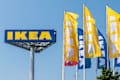 Bratislava, Slovakia - 06102025: IKEA logo and flags against a blue sky in Bratislava, Slovakia. Brand colors yellow and blue.