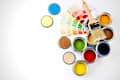 Colorful paint cans arranged with a paintbrush and color swatches, showcasing various paint colors.