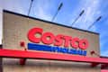 Calgary, Alberta, Canada. March 8, 2026. Exterior of a Costco Wholesale warehouse building featuring the large red and blue brand logo against a blue sky.
