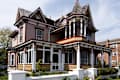 Beautiful colorful wooden Victorian style residential building with porch and balcony on a bright summer spring day.