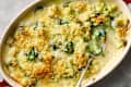 Creamy broccoli casserole topped with golden breadcrumbs in a baking dish, with a serving spoon.