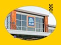 Exterior view of an Aldi store featuring large windows, a brick column, and a colorful sign.