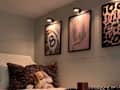 Animal print artwork on wall above bed in dorm room.