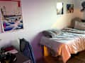 Desk in front of dorm room bed.