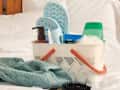 Closeup of a basket filled with bath supplies on a bed.