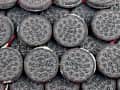 A pile of Oreo cookies with embossed designs and visible cream filling.