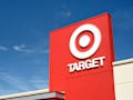Red Target store sign with logo against a clear blue sky.