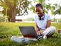Student working on laptop on college campus.
