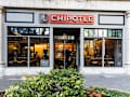 CHARLOTTE, NC, USA-26 JAN 2020: A Chipotle fast food restaurant in uptown Charlotte.  A man exits while two people sit inside.