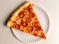 Pepperoni pizza slice on a paper plate