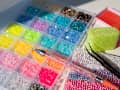 Bedazzling kit on a clean white background with colorful rhinestones, tweezers, embellished items, and a sparkling pink bedazzling pen. A trendy DIY craft setup for adding glamorous details to accessories and everyday objects
