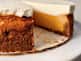 A photo of a whole sweet potato cheesecake on a plate with a slice missing.