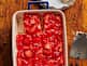 strawberry pretzel salad in baking sheet with a slice