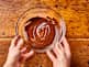 someone is holding a bowl of melted chocolate