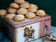 Cream cheese cookies dusted with powdered sugar stacked on a vintage tin box.