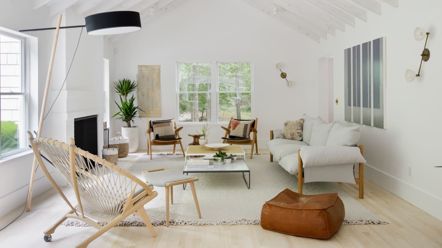 Contemporary minimalist style interior design of light studio apartment  with wooden table and chairs in dining zone between open kitchen and living  room with white walls and parquet floor Stock Photo 