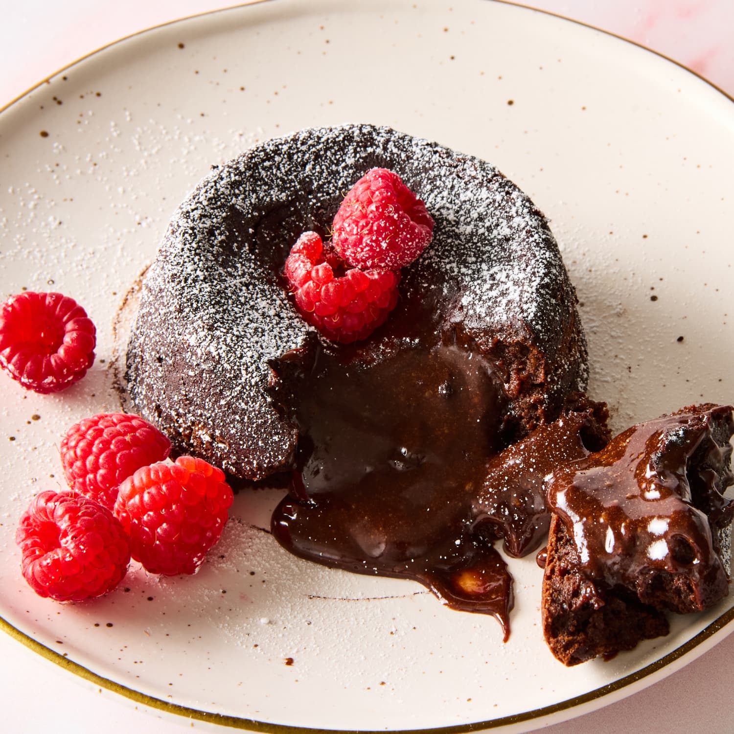 Chocolate lava cake with powdered sugar and raspberries