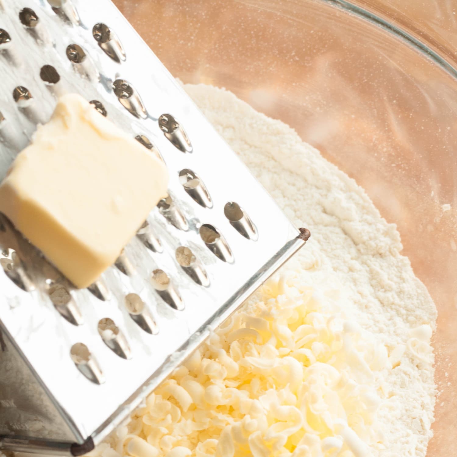 Grate your cold butter over the large holes of a plane grater and