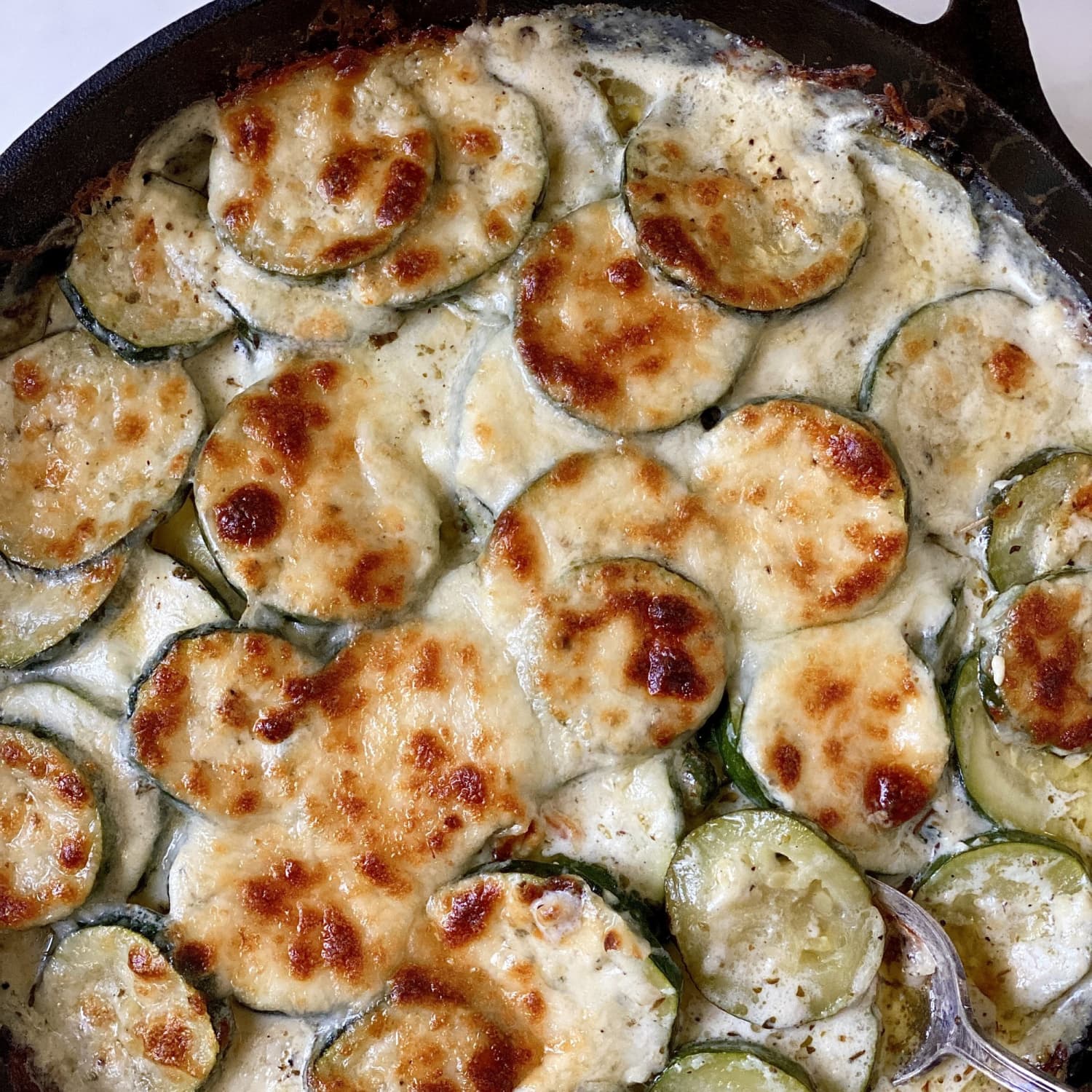 https://cdn.apartmenttherapy.info/image/upload/f_jpg,q_auto:eco,c_fill,g_auto,w_1500,ar_1:1/k%2Frecipes%2F2023%2F2023-08-creamy-parmesan-zucchini%2Fcreamy-parmesan-zucchini-lead