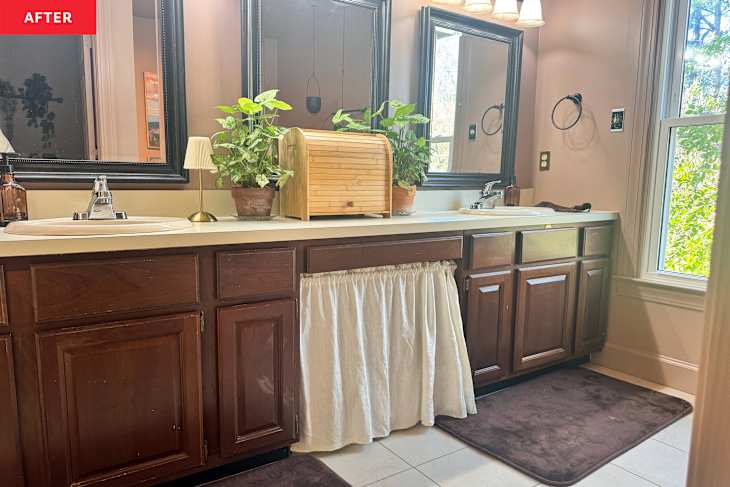 Bathroom vanity with dark wood cabinets, white sink, potted plants, and a bamboo storage box.