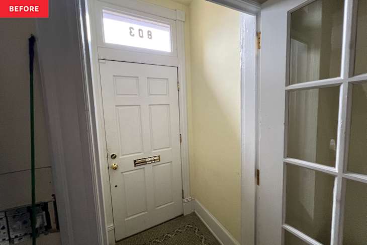 Entryway with white door, yellow walls, and mosaic floor.