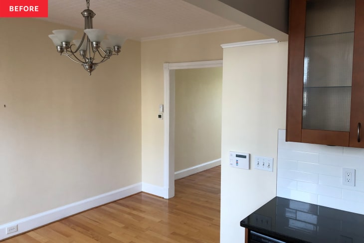 Bare dining room with hanging light fixture and corner of kitchen cabinets