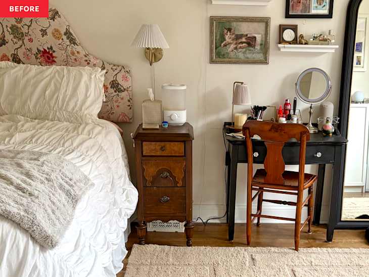 Cozy bedroom corner with a floral headboard, white bedding, wooden nightstand, and a black desk with a mirror.