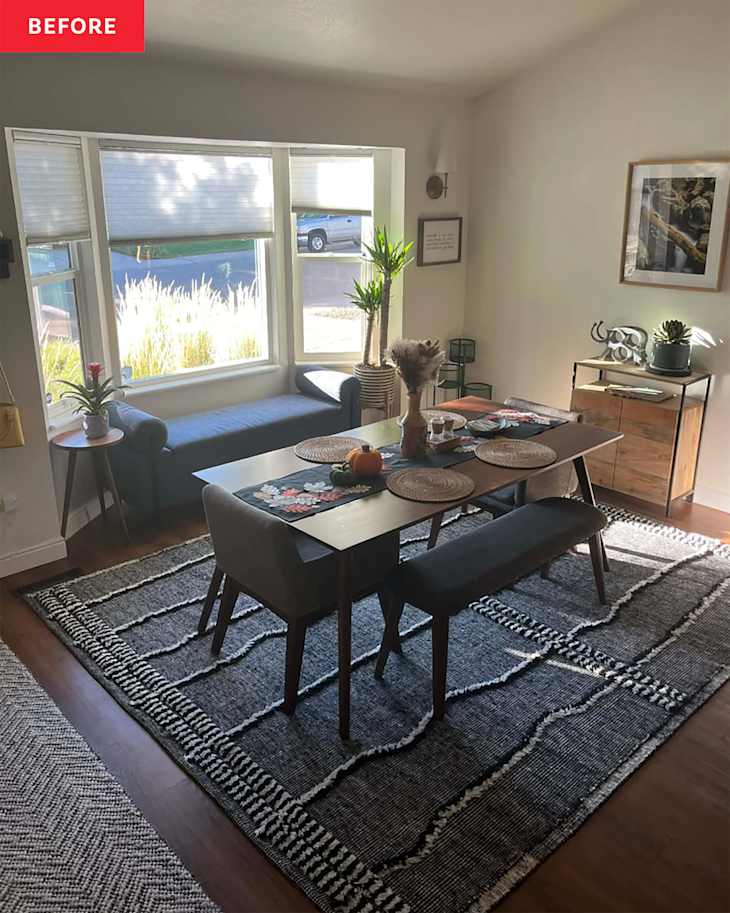Cozy dining area with a wooden table, gray chairs, a bench, and a patterned rug, featuring plants and natural light.