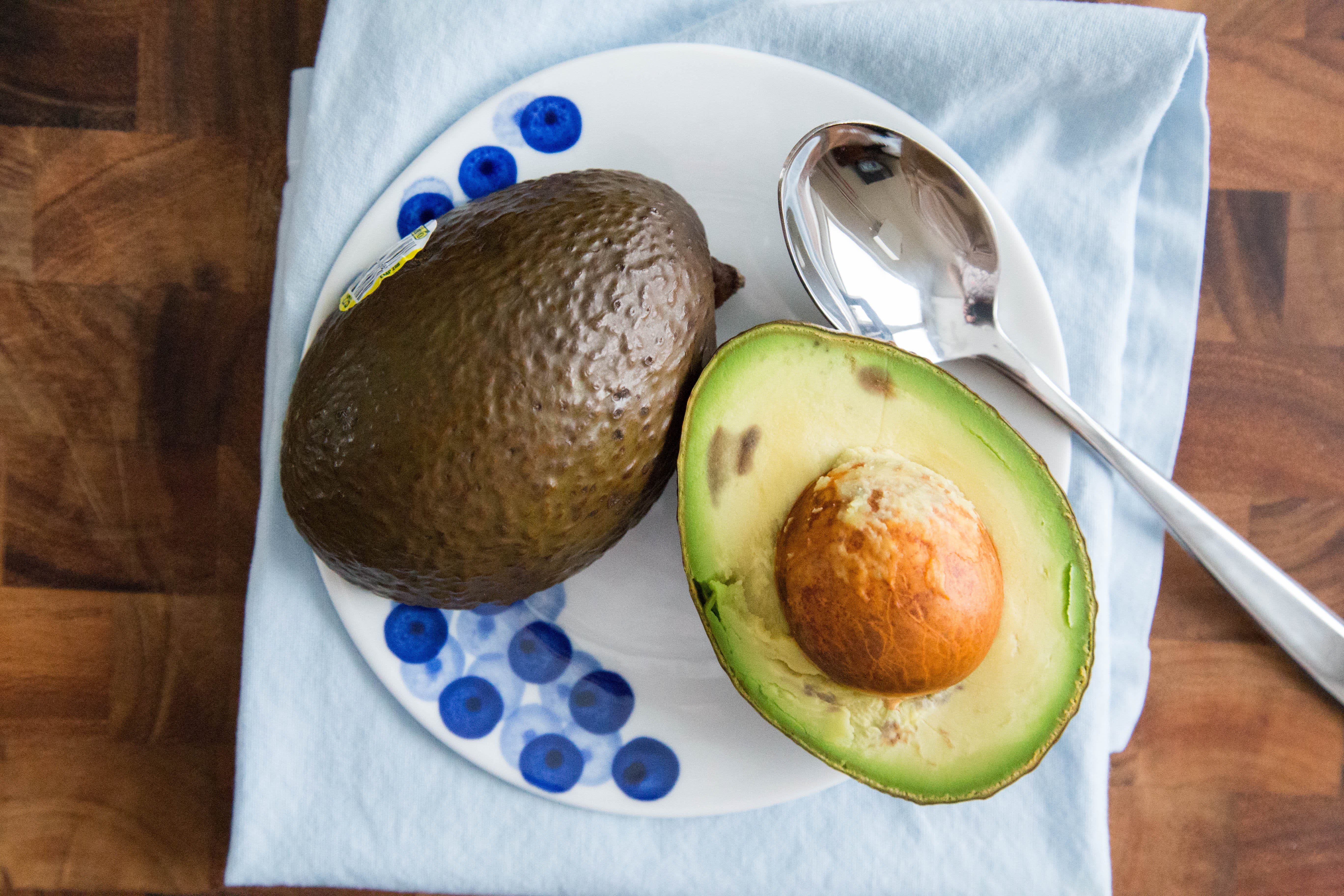 A ripe avocado sits prominently, flanked by a flurry of diced