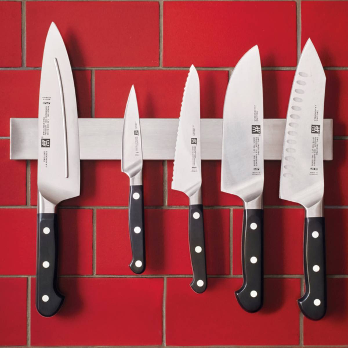 As assortment of kitchen knives flat laid on a neutral background