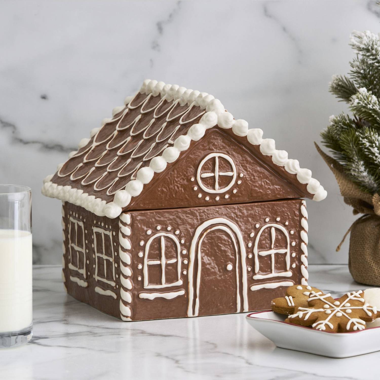 A whimsical stoneware gingerbread house from Pottery Barn, detailed with white icing-like glaze.