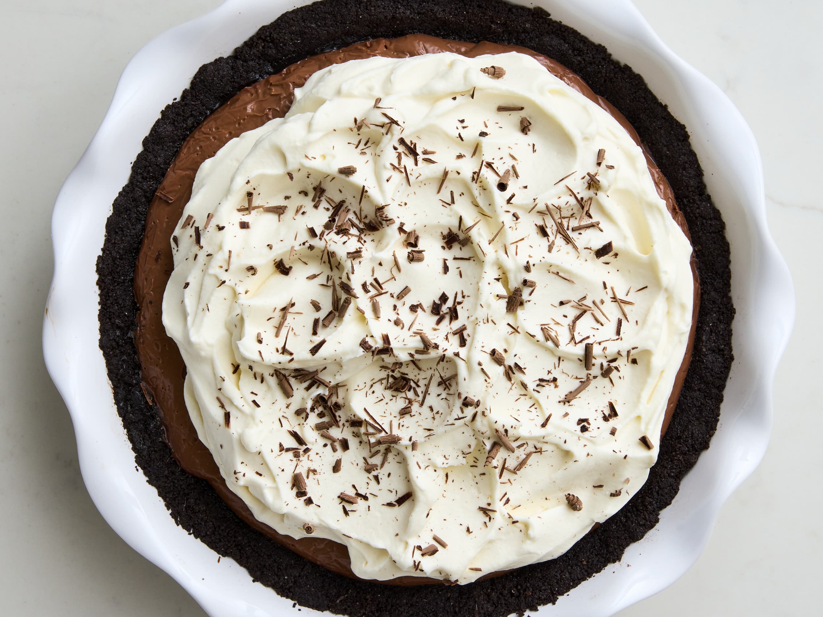 Overhead view of a chocolate cream pie topped with whipped cream and chocolate shavings